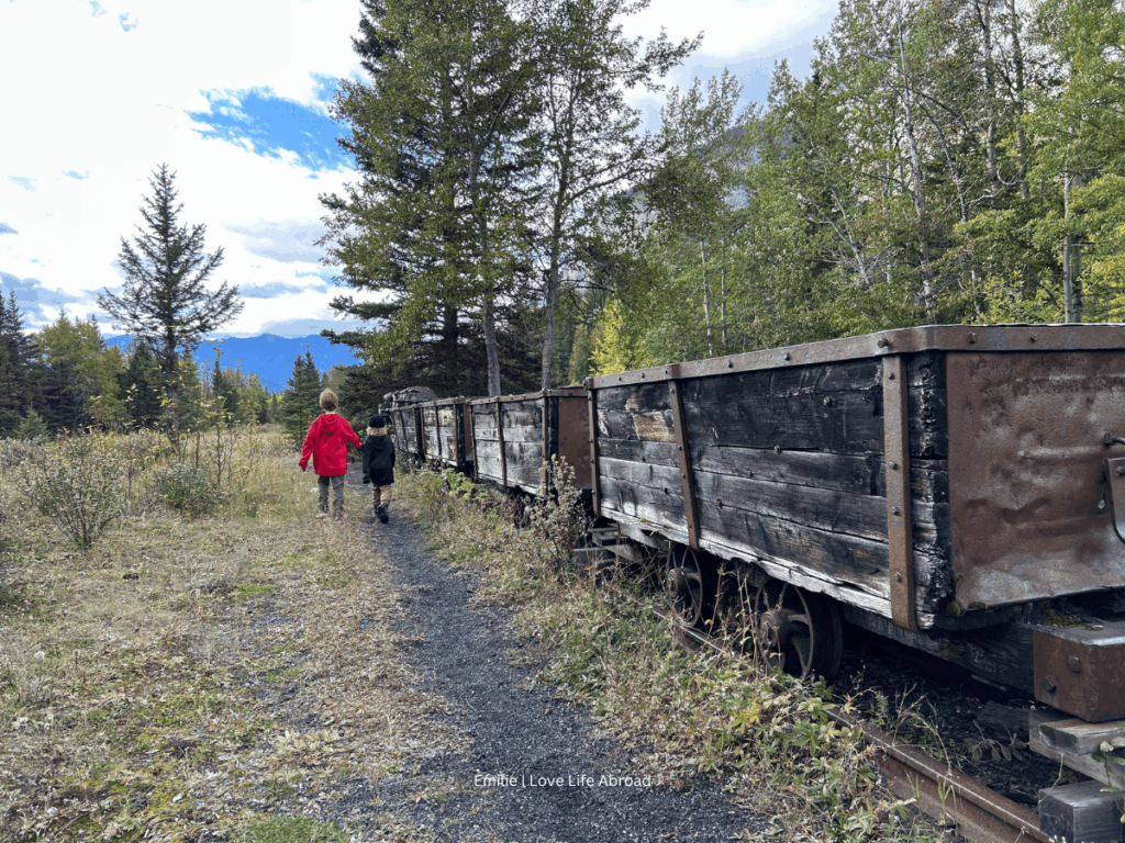 Two children walking to an old train at Lower Bankhead Trail in Banff National Park