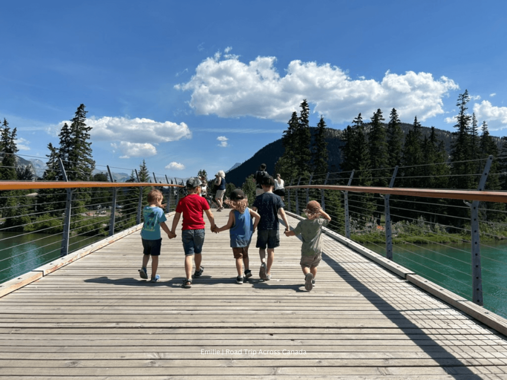 Kids walking over the Bow River in Banff on the pedestrian bridge